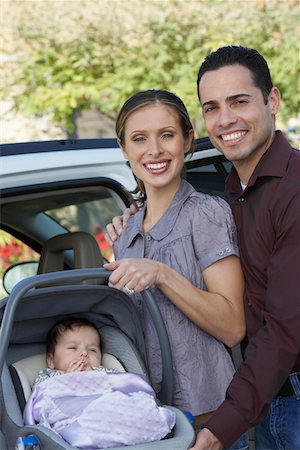 Portrait of couple with baby (1-6 months) in carrier by car Stock Photo - Premium Royalty-Free, Code: 693-06019571