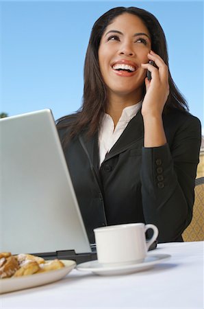 Mid adult business woman talking on phone in front of laptop Foto de stock - Sin royalties Premium, Código: 693-06019611