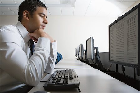 pc desktop - Man sitting at desk in front of computer Fotografie stock - Premium Royalty-Free, Codice: 693-06019703