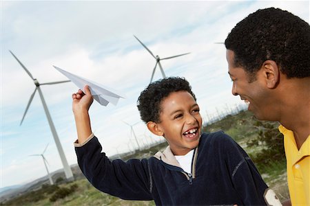 paper plane son - Father and son (7-9) playing with paper plane at wind farm Stock Photo - Premium Royalty-Free, Code: 693-06019788