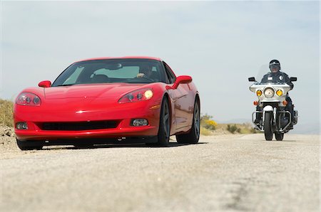 sports car and person - Traffic cop on motorcycle stopping sports car Foto de stock - Sin royalties Premium, Código: 693-06019847