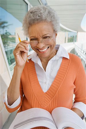 Woman holding book at school, smiling, portrait Stock Photo - Premium Royalty-Free, Code: 693-06019933