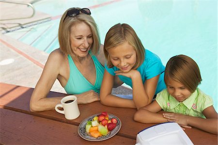 simsearch:693-03307029,k - Two Girls (7-9) and Grandmother Watching portable television by swimming pool. Foto de stock - Sin royalties Premium, Código: 693-06013543