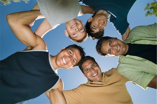 Boy (13-15) with brothers and father in huddle, view from below. Stock Photo - Premium Royalty-Free, Image code: 693-06013618