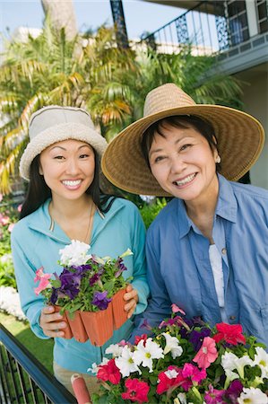 family backyard gardening not barbeque - Mother and daughter in garden, smiling, (portrait) Stock Photo - Premium Royalty-Free, Code: 693-06013668