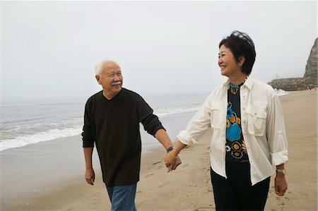 Mature couple holding hands, walking on beach Stock Photo - Premium Royalty-Free, Code: 693-06013691