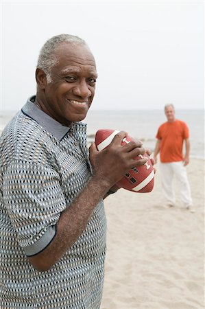 Two senior men playing american football on beach Stock Photo - Premium Royalty-Free, Code: 693-06013748