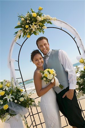 simsearch:693-03686309,k - Bride and Groom under archway on beach, (portrait) Stock Photo - Premium Royalty-Free, Code: 693-06013789