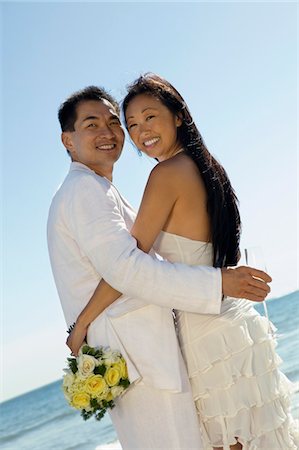Bride and Groom embracing on beach, (portrait) Stock Photo - Premium Royalty-Free, Code: 693-06013794