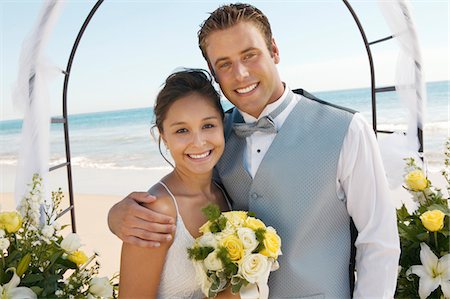 Bride and Groom under archway on beach, (portrait) Stock Photo - Premium Royalty-Free, Code: 693-06013790