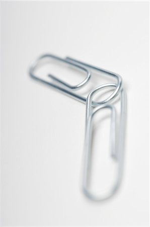 fermaglio per fogli - Two silver paper clips on white background Fotografie stock - Premium Royalty-Free, Codice: 693-06020309