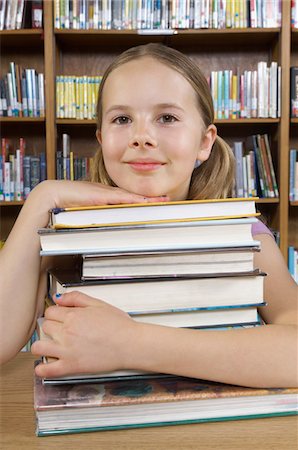 school girl holding pile of books - School girl hugging books in library, portrait Stock Photo - Premium Royalty-Free, Code: 693-06020478