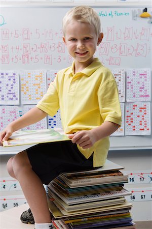 rentrée scolaire - Écolier assis sur une pile de livres Photographie de stock - Premium Libres de Droits, Code: 693-06020658