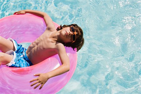 Boy on Float Tube in Swimming Pool Foto de stock - Sin royalties Premium, Código: 693-06020733