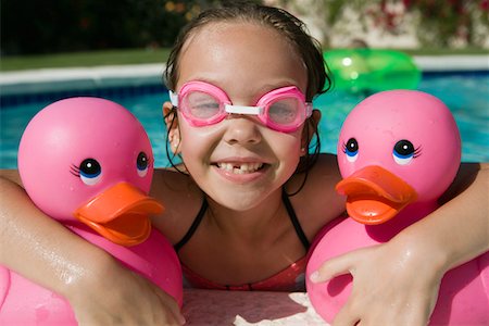 simsearch:693-06020819,k - Jeune fille au bord piscine détenant des canards en caoutchouc rose Photographie de stock - Premium Libres de Droits, Code: 693-06020765