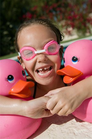 simsearch:693-06020819,k - Jeune fille au bord piscine détenant des canards en caoutchouc rose Photographie de stock - Premium Libres de Droits, Code: 693-06020766