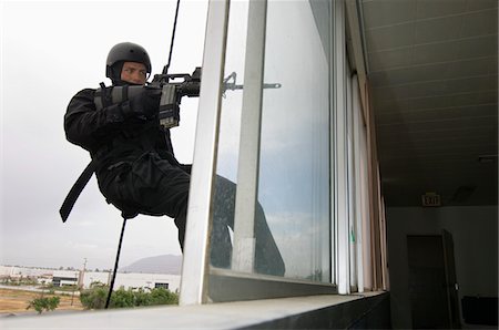 poliziotto (uomo) - SWAT Team Officer Rappelling and Aiming Gun Fotografie stock - Premium Royalty-Free, Codice: 693-06021246