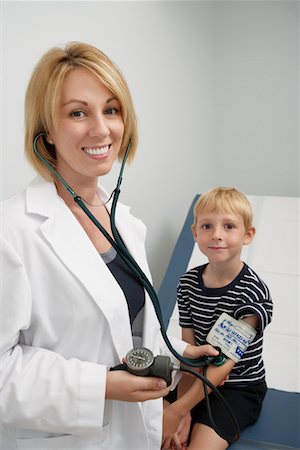 female doctor and child patient - Female doctor taking blood pressure of boy Stock Photo - Premium Royalty-Free, Code: 693-06021423