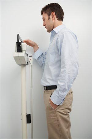 Man standing on weighing scales in hospital Stock Photo - Premium Royalty-Free, Code: 693-06021430