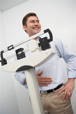 Man standing on weighing scales in hospital Stock Photo - Premium Royalty-Free, Code: 693-06021431