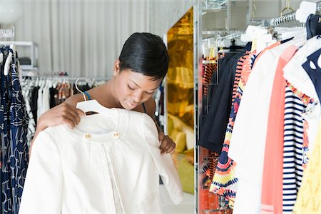 Woman considers white jacket in clothes store Stock Photo - Premium Royalty-Free, Code: 693-06021467
