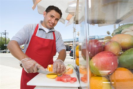 seller (male) - Portrait of male street vendor chopping fruit Stock Photo - Premium Royalty-Free, Code: 693-06021528