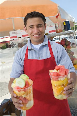 Portrait of male street vendor holding fruit salad Stock Photo - Premium Royalty-Free, Code: 693-06021529