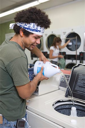 Young man washing clothes at launderette Stock Photo - Premium Royalty-Free, Code: 693-06021545