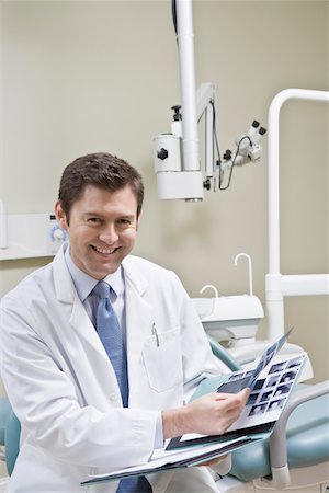 doctor looking at xray - Dentist leafing through medical record Stock Photo - Premium Royalty-Free, Code: 693-06021599
