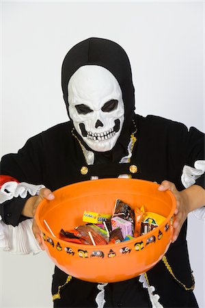 simsearch:693-06021611,k - Portrait of boy (7-9) wearing skeleton mask, holding candy bowl Stock Photo - Premium Royalty-Free, Code: 693-06021620