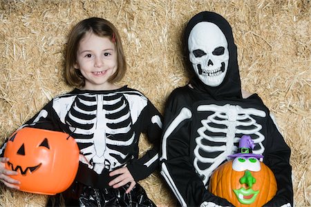 Portrait of girls (7-9) wearing skeleton costumes, with jack-o-lanterns Stock Photo - Premium Royalty-Free, Code: 693-06021634