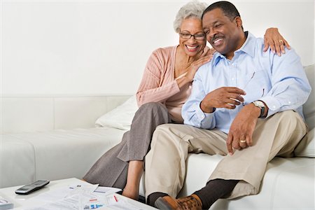 personal finance - Cheerful Senior Couple On Couch Stock Photo - Premium Royalty-Free, Code: 693-06021711