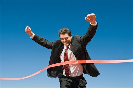 run suit low angle - Businessman Crossing the Winning Line Stock Photo - Premium Royalty-Free, Code: 693-06021725