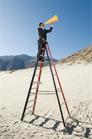 Businessman on Stepladder Using Megaphone in Desert Stock Photo - Premium Royalty-Free, Code: 693-06021781