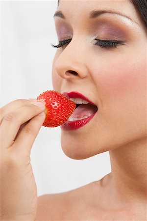 simsearch:693-06021794,k - Woman eating strawberry Stock Photo - Premium Royalty-Free, Code: 693-06021794