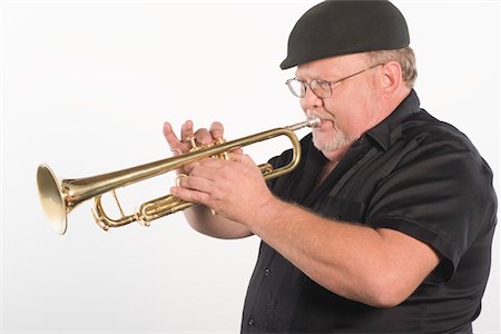 simsearch:693-06021858,k - Mature man in flat cap playing the trumpet Stock Photo - Premium Royalty-Free, Code: 693-06021857