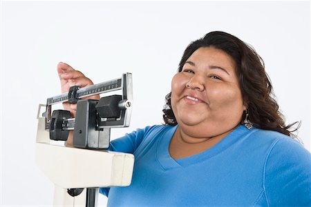 fat black woman pictures - Woman using weight scales Stock Photo - Premium Royalty-Free, Code: 693-06021867