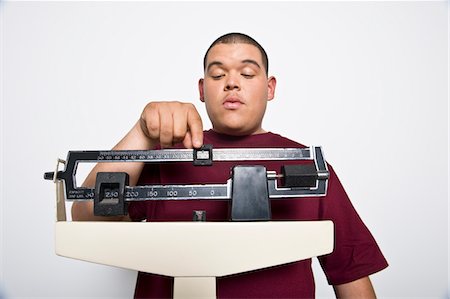 Teenage (16-17) boy using weight scales Stock Photo - Premium Royalty-Free, Code: 693-06021886