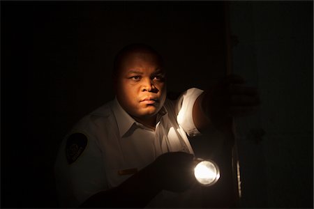 Security guard investigates with flashlight Stock Photo - Premium Royalty-Free, Code: 693-06022148