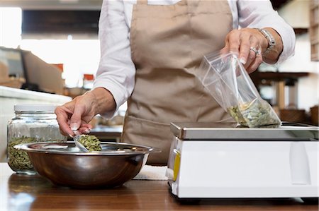 Midsection of an employee measuring ingredient on weight scale in spice store Stock Photo - Premium Royalty-Free, Code: 693-06120773