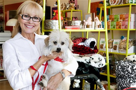 retail industry - Portrait of a happy senior woman carrying dog in pet shop Foto de stock - Sin royalties Premium, Código: 693-06120788