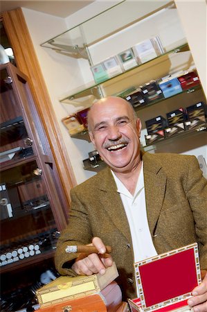 Portrait of cheerful mature man smoking cigar in tobacco store Foto de stock - Sin royalties Premium, Código: 693-06120807