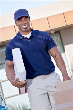 simsearch:693-06323978,k - Portrait of a happy delivery man carrying packages Stock Photo - Premium Royalty-Free, Code: 693-06120810