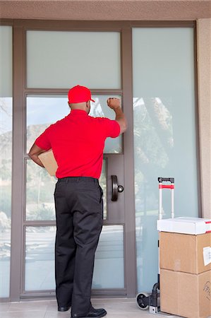 Vue arrière d'un livreur de frapper à la porte Photographie de stock - Premium Libres de Droits, Code: 693-06120827