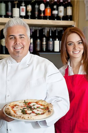 Portrait d'un chef heureux holding pizza avec belle serveuse Photographie de stock - Premium Libres de Droits, Code: 693-06120859