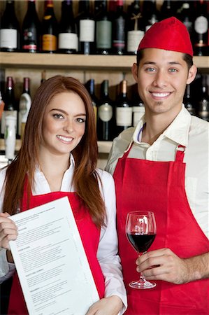 Portrait of young wait staff with wine glass and menu card in bar Foto de stock - Sin royalties Premium, Código: 693-06120853