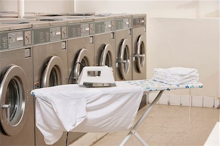 Ironing board with washing machines in Laundromat Stock Photo - Premium Royalty-Free, Code: 693-06120894