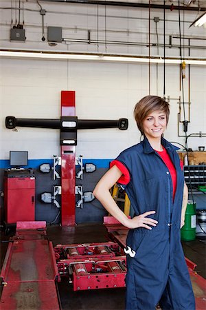 repair shop - Happy young female mechanic with hands on hips in automobile repair shop Foto de stock - Sin royalties Premium, Código: 693-06120954