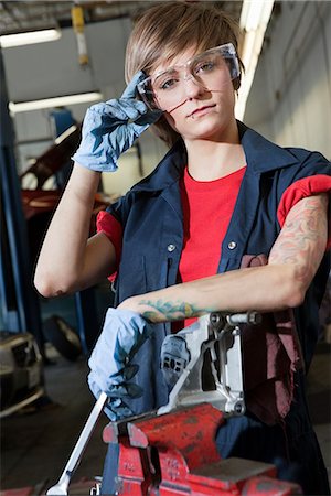 female mechanic - Portrait of a young female mechanic wearing protective eyewear in garage Foto de stock - Sin royalties Premium, Código: 693-06120964