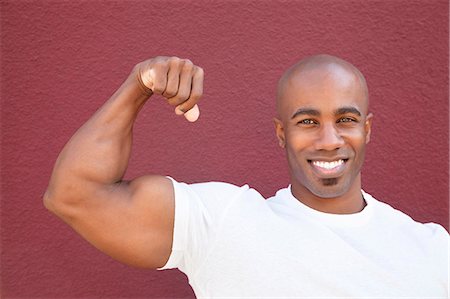 simsearch:693-06323954,k - Portrait of a young African American man flexing muscles over colored background Fotografie stock - Premium Royalty-Free, Codice: 693-06120982